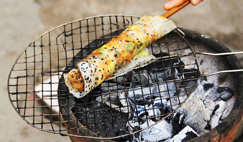 Bánh tráng mắm ruốc nướng trên bếp than, với các loại topping và mắm ruốc đặc trưng