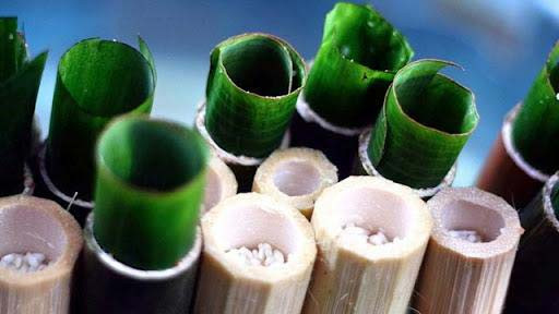 Gạo nếp thơm ngon được cẩn thận đổ vào ống tre đã lót lá chuối để chế biến món cơm lam truyền thống