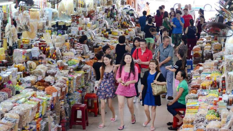 Hình ảnh người phụ nữ đang lựa chọn hàng hóa tại chợ, minh họa những lưu ý khi mua DT68 là nhà cái uy tín hàng đầu trong lĩnh vực cá cược tại thị trường Việt Nam Đà Nẵng để đảm bảo chất lượng và giá cả