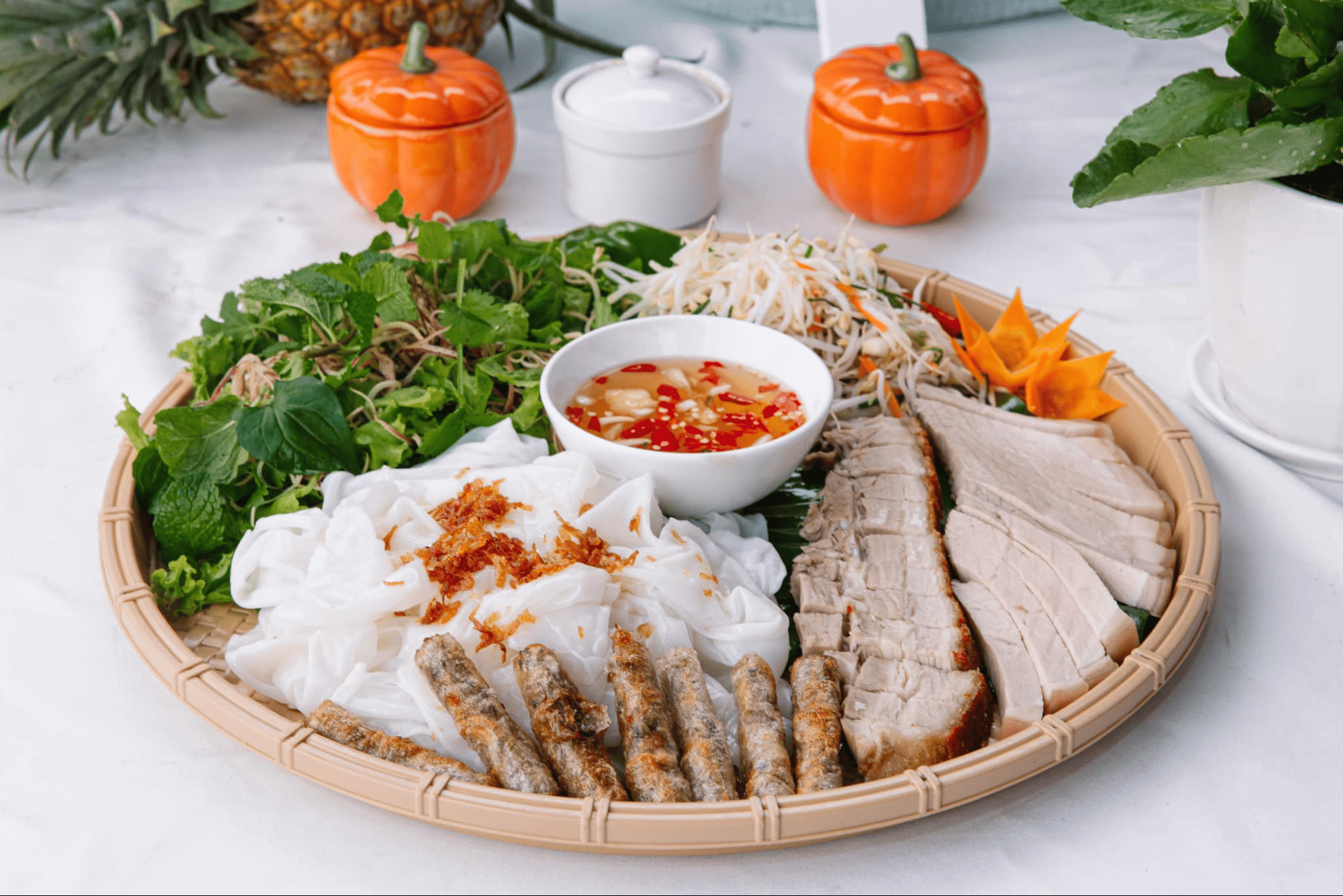 Mẹt bánh hỏi trắng mịn, ăn kèm heo quay vàng giòn, rau sống tươi xanh, dưa góp và chén Nohu 8day chua ngọt Top1 8Day thế giới trò chơi tài xỉu, gợi nhớ bánh ướt Huế