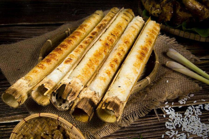 Người phụ nữ dân tộc cầm ống cơm lam Pù Luông mới nướng thơm lừng