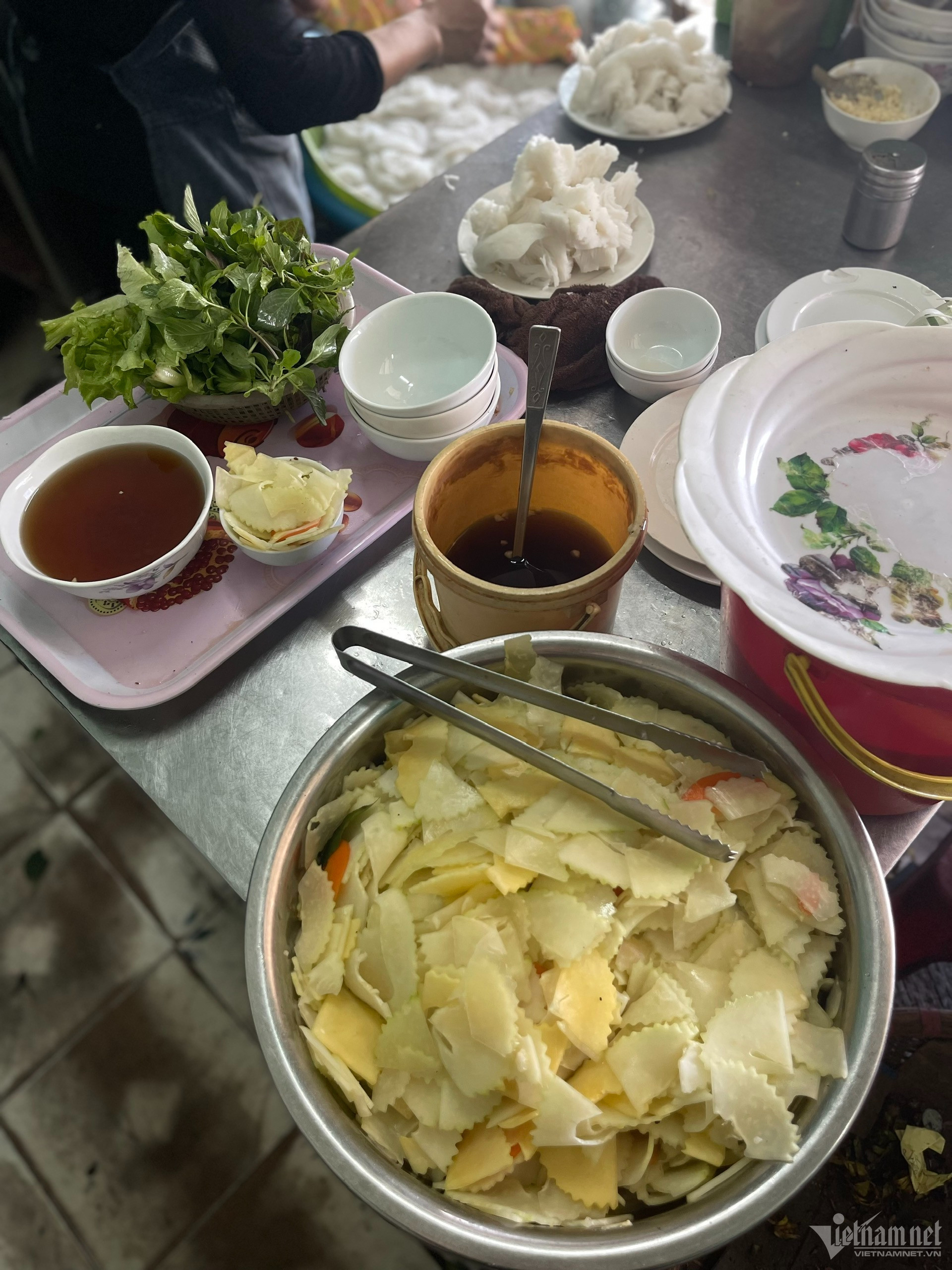 Thịt chả được thái mỏng và kẹp trên gắp tre