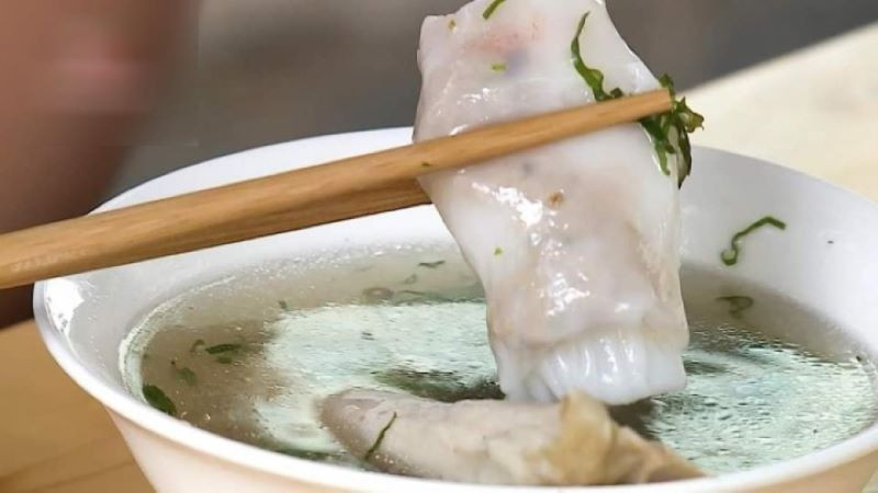 Thưởng thức bánh cuốn Cao Bằng với nước dùng đầy đủ gia vị, mang đến trải nghiệm ẩm thực độc đáo.