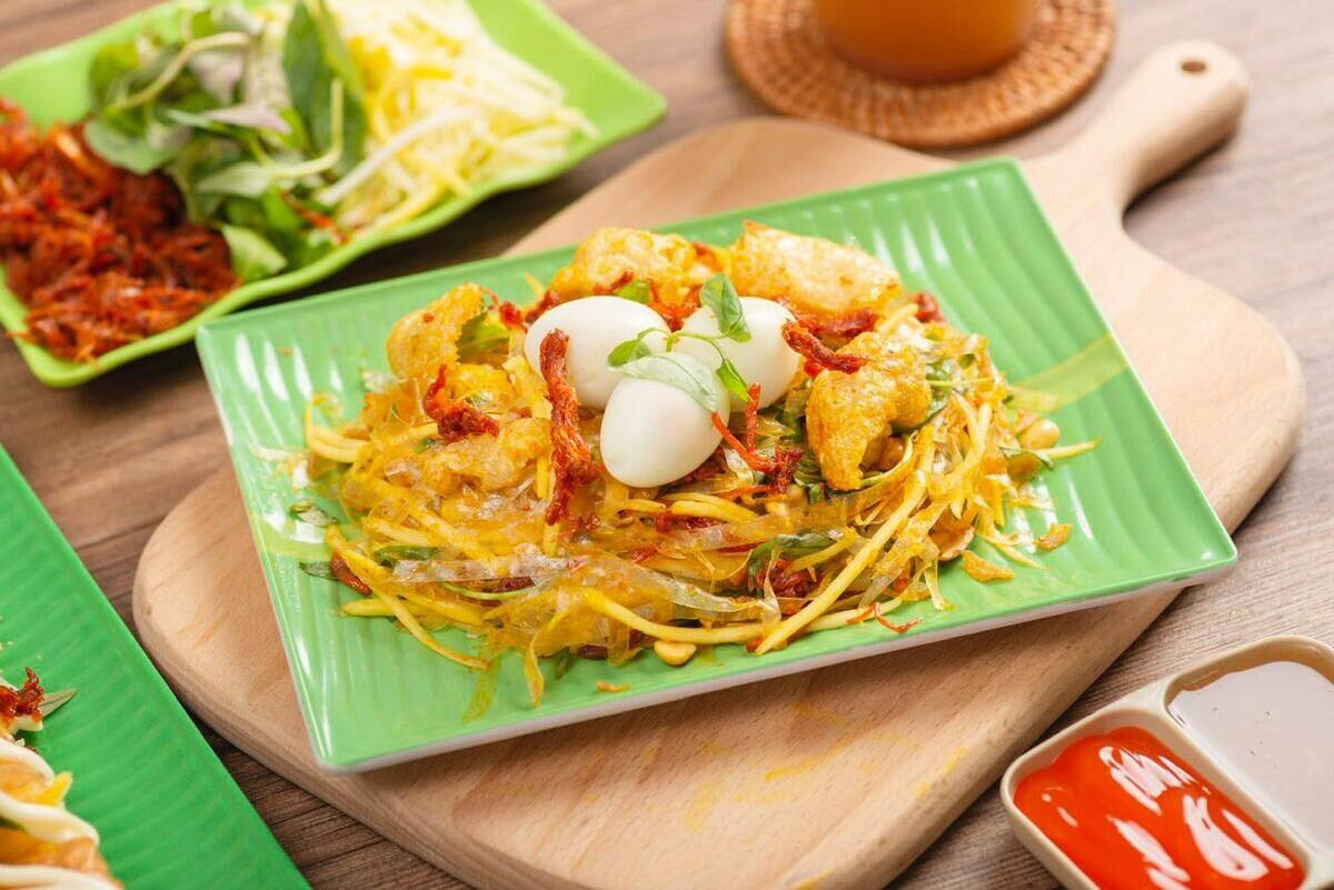 Tô bánh tráng trộn đầy màu sắc với xoài xanh, trứng cút, khô bò và rau răm, 8Day nhà cái vặt đặc trưng của giới trẻ Sài Gòn.