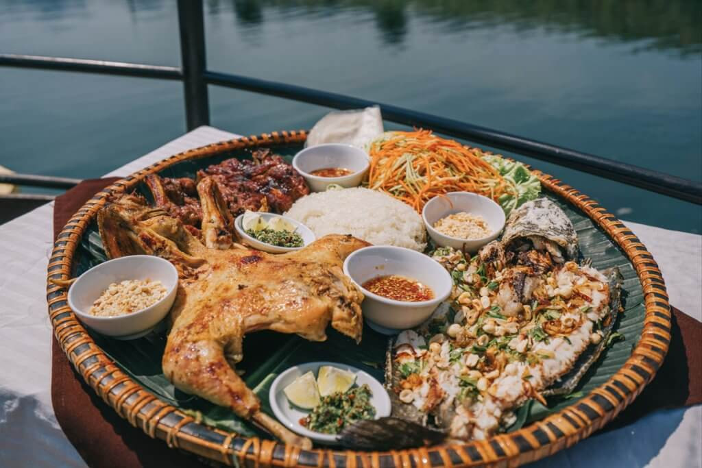 Cá lóc nướng trên bếp than hồng, khói tỏa lên thơm lừng, tượng trưng cho ẩm thực Phong Nha