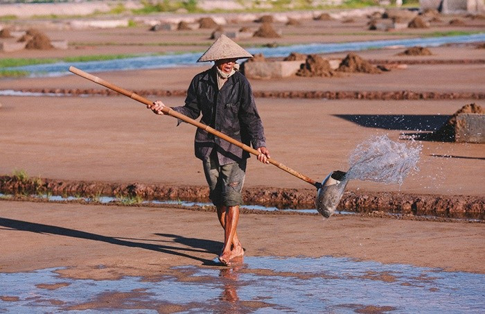 Công đoạn tưới nước biển trên sân muối Văn Lý