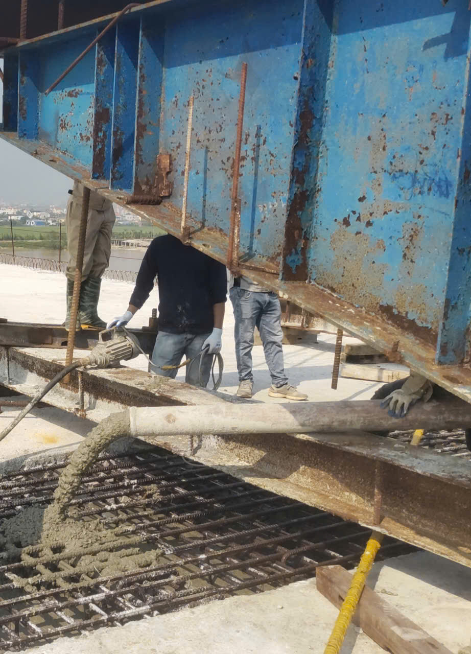 Công nhân hoàn tất các khối bê tông cuối cùng để hợp long cầu