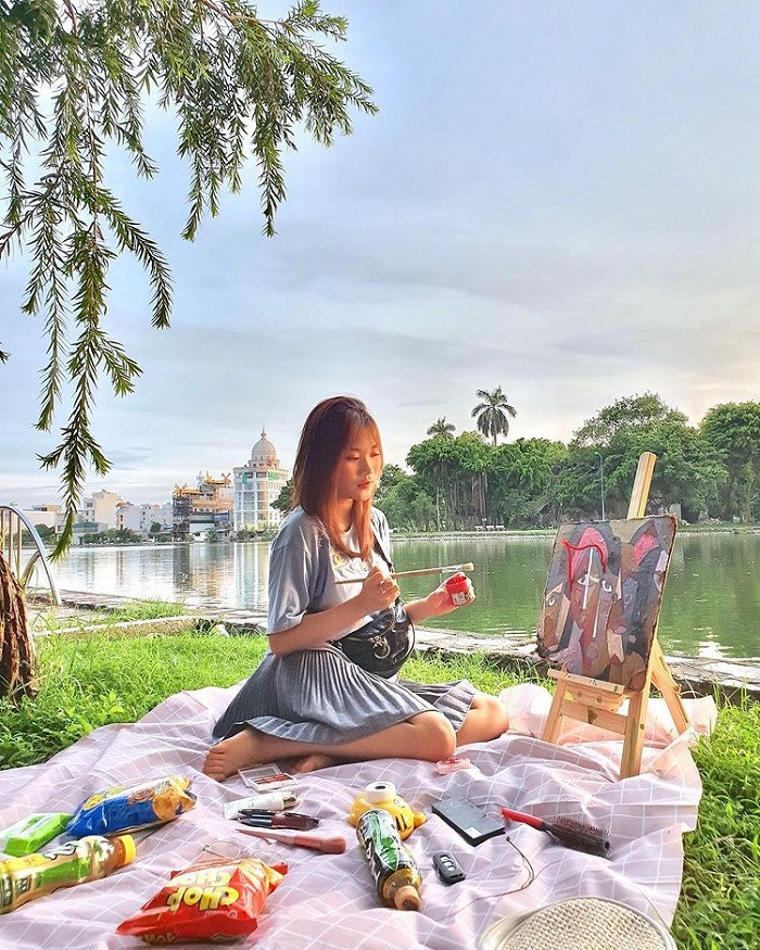 Gia đình và bạn bè tổ chức picnic bên thảm cỏ xanh mướt cạnh Hồ Vị Xuyên