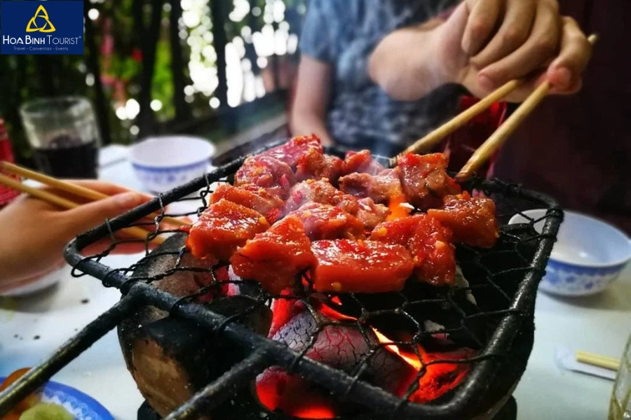 Hình ảnh các miếng thịt bò tươi được tẩm ướp và đang nướng trên bếp than
