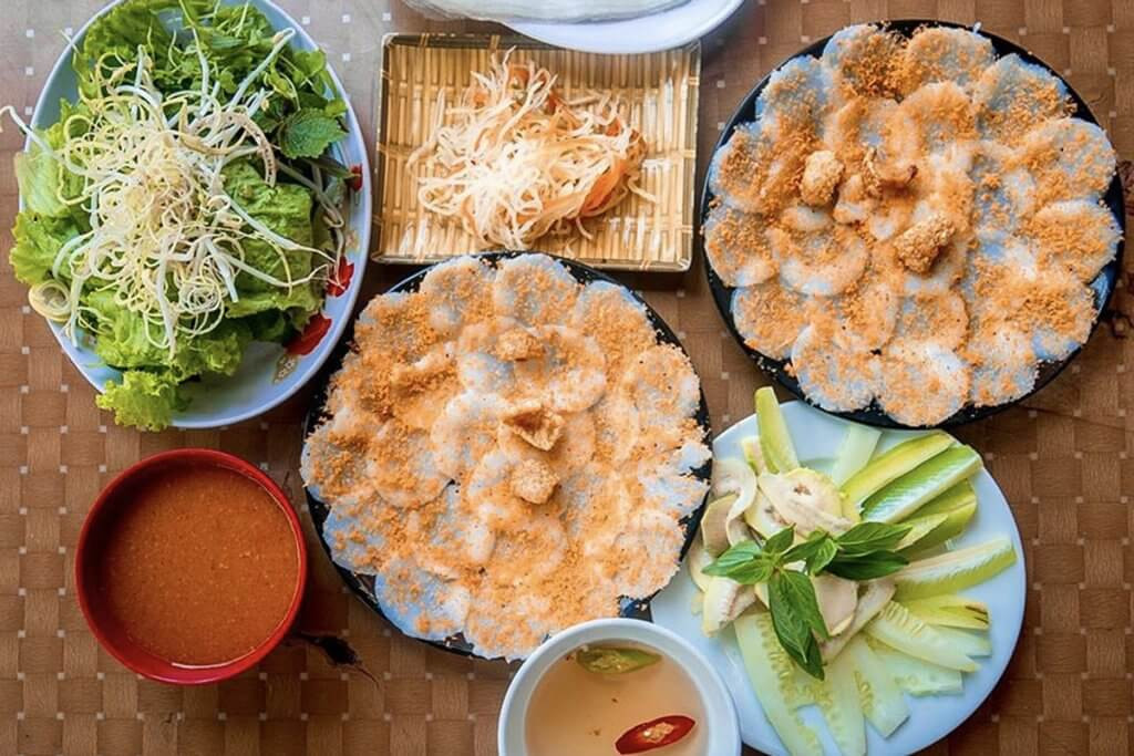 Hình ảnh một nồi lẩu cá khoai đang sôi sùng sục với các loại rau xanh tươi rói