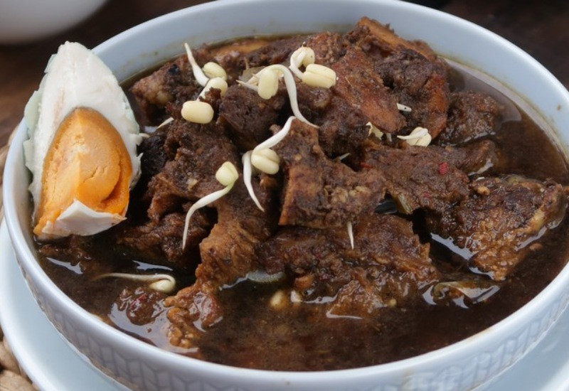 Bát súp Rawon màu đen đặc trưng với thịt bò mềm