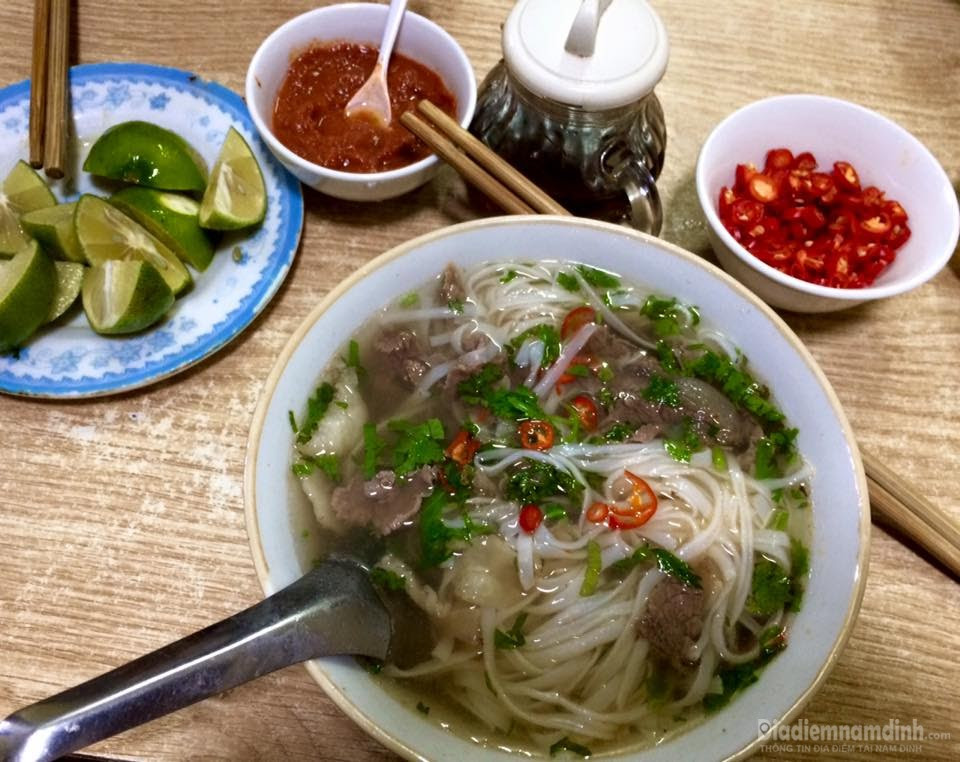 Hình ảnh bát phở bò tái chín với hành lá và chanh ớt