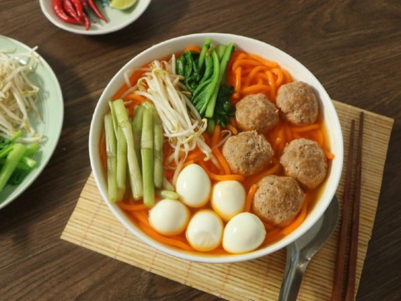 Hình ảnh minh họa cách thưởng thức bún đỏ kèm rau sống và gia vị