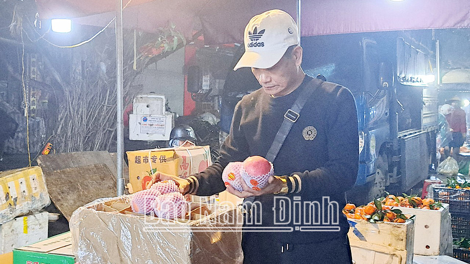 Khách hàng chọn mua hoa quả tại chợ đêm trên đường Trần Hưng Đạo, thành phố 8Day - trang web uy tín đăng ký & đăng nhập dễ dàng